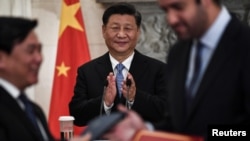 中国希腊两个经贸官员签署协议之际，中国国家主席习近平站在他们身后鼓掌。（2019年11月11日）