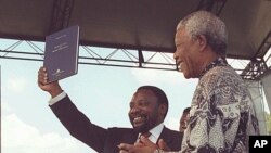 Presidente da Assembleia Constituinte sul-africana, Cyril Ramaphosa, mostrando um exemplar da nova constituição da África Sul pouco depois de rubricada pelo então presidente Nelson Mandela, Dezembro de 1996 