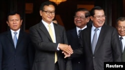 Tokoh oposisi Kamboja Sam Rainsy berjabat tangan dengan Perdana Menteri Hun Sen (kanan) - (foto: dok).