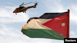 Sebuah helikopter terlihat di samping bendera Yordania selama latihan militer Eager Lion di perbatasan Yordania-Arab Saudi, sebelah selatan Amman, 17 Mei 2017. (Foto: REUTERS/Muhammad Hamed)