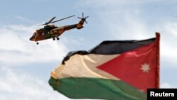 요르단 수도 암만 남부 사우디 국경지역에 실시된 군사훈련에서 요르단 국기를 배경으로 헬리콥터가 날고 있다. (자료사진)