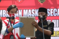 Kedua kandidat calon Wali Kota, Gibran Rakabuming Raka (baju merah putih dan masker merah putih) diusung jalur partai politik dan Bagyo Wahyono (baju hitam dan masker hitam) diusung jalur perseorangan atau independen, saat deklarasi komitmen jaga protokol kesehatan selama tahapan Pilkada , Kamis (10/9). (Foto : Humas Pemkot Surakarta)