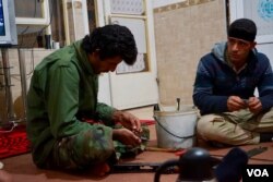 A peshmerga fighter sets about fixing a 30-year-old AK-47 hours before a battle with Islamic State militants, Nov. 6, 2016. (J. Dettmer/VOA)