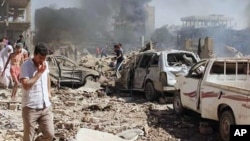 Warga Suriah menginspeksi kerusakan setelah dua bom meledak di kota Qamishli, Suriah Rabu (27/7).