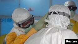 A U.S. doctor in a protective suit in Liberia adjust that of a colleague before entering an Ebola treatment unit in Monrovia in this photo released Sept. 16, 2014.