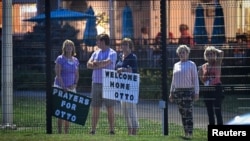 FILE - Local residents hold signs of support to welcome home Otto Warmbier at Lunken Airport in Cincinnati, Ohio, June 13, 2017.