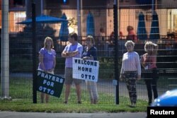 Local residents hold signs of support to welcome home Otto Warmbier at Lunken Airport in Cincinnati, Ohio, June 13, 2017.