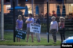 Local residents hold signs of support to welcome home Otto Warmbier at Lunken Airport in Cincinnati, Ohio, June 13, 2017.