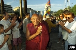 FILE - Tibetan monk Palden Gyatso, a political prisoner for decades in China, makes a gesture of prayer, July 9, 2000, in Nice, France, to a crowd that came to show support for him.