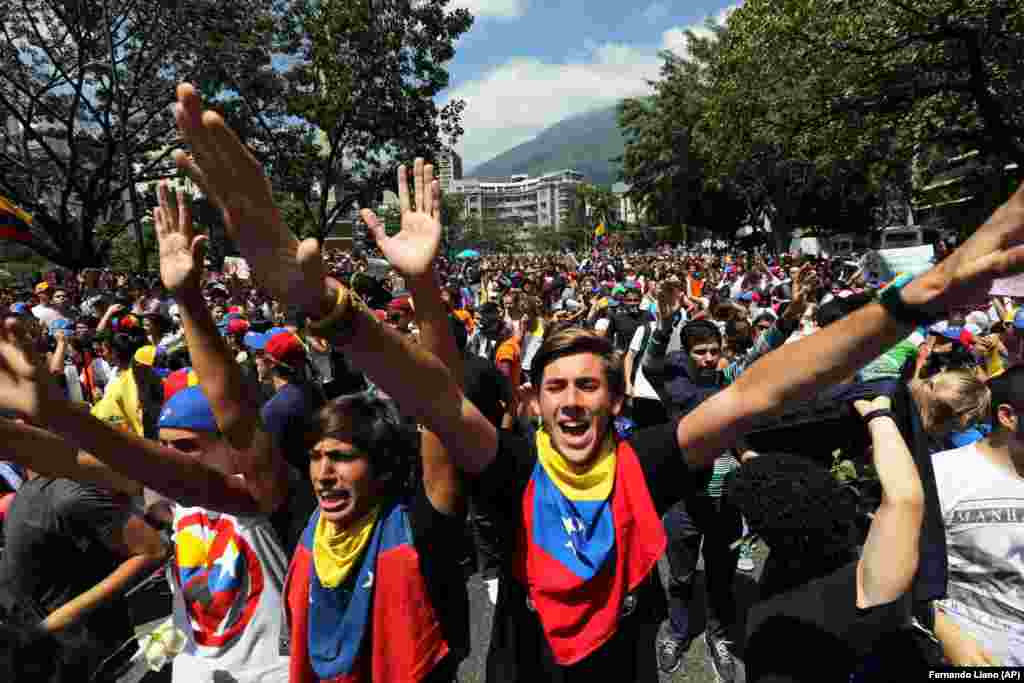 Estudantes vão as ruas de Caracas para protestar contra o presidente venezuelano Nicolas Maduro, na sexta-feira, 14 de fevereiro, 2014. O protesto foi contra os assassinatos de dois estudantes universitários que foram baleados em incidentes diferentes após um protesto anti-governo que exigiu a libertação de manifestantes estudantis que haviam sido presos em várias partes do país.