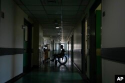 A patient attends in a corridor of the government-run Rafik Hariri University Hospital during a power outage in Beirut, Lebanon, Aug. 11, 2021.