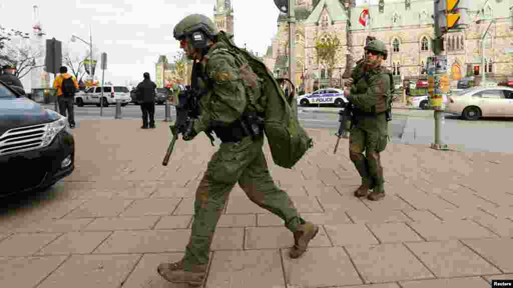 Des agents de la GRC, armés jusqu&#39;aux dents,&nbsp; lancent un assaut à l&#39;édifice du Parlement après une fusillade à Ottawa, le 22 Octobre 2014. 