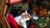 FILE - Soldiers distribute pictures of a member of extremist group Abu Sayyaf, Isnilon Hapilon, who has a U.S. government bounty of $5 million for his capture, in Butig, Lanao del Sur in southern Philippines, Feb. 1, 2017. 