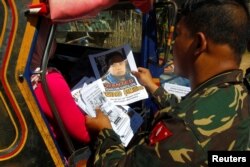 FILE - Soldiers distribute pictures of a member of extremist group Abu Sayyaf, Isnilon Hapilon, in Butig, Lanao del Sur in southern Philippines, Feb. 1, 2017.