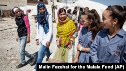 Nobel Peace Prize winner Malala Yousafzai, center, speaks with Syrian refugee girls during her visit in 2015 to Bekaa Valley in east Lebanon. (Malin Fezehai/HUMAN for the Malala Fund via AP)