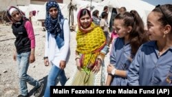 Nobel Peace Prize winner Malala Yousafzai, center, speaks with Syrian refugee girls during her visit to Bekaa Valley, east Lebanon on July 12, 2015.