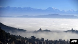 Gunung Langtang terlihat menyembul di balik lembah Kathmandu yang berselimut kabut, 10 Desember 2014. (Foto: dok). Sebuah helikopter jatuh di kawasan pegunungan Nepal, menewaskan tujuh penumpangnya, termasuk menetri pariwisata negara tesebut, Rabu (27/2).