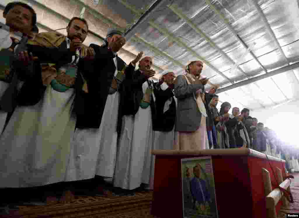 Mourners recite prayers during the funeral of Bashar Arhab, a victim of one of Friday's suicide bombings at mosques, in Sanaa, March 23, 2015.