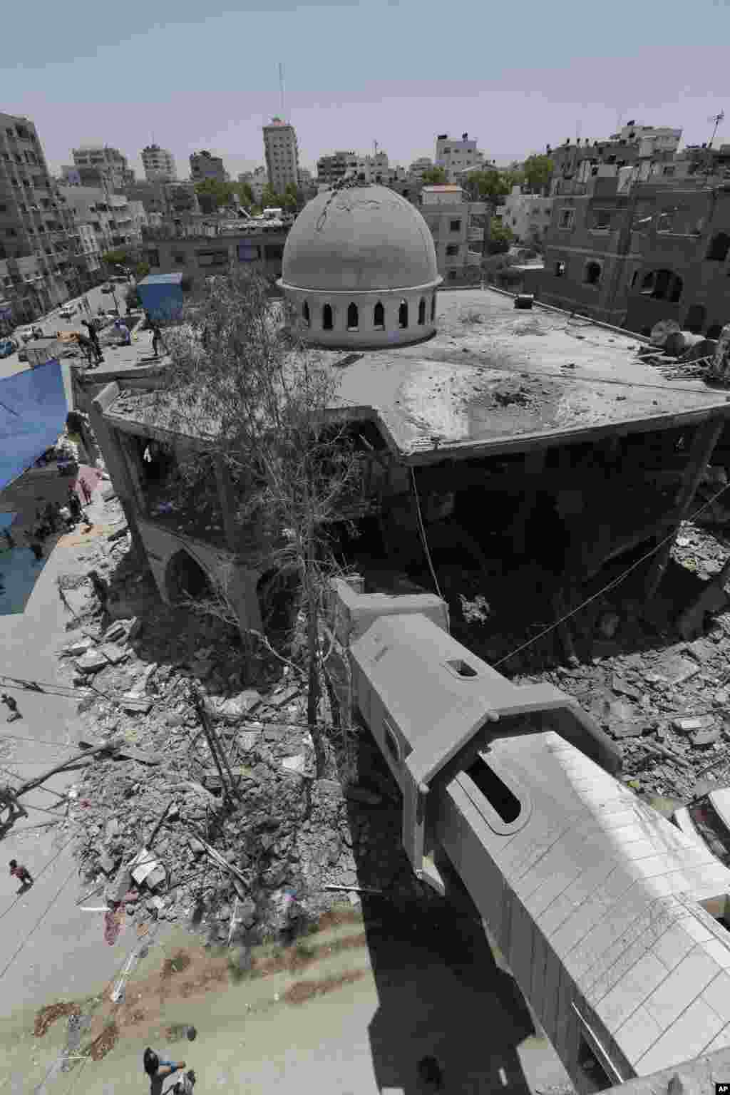 A fallen minaret, (bottom r), is seen as Palestinians inspect the damage to the Al-Sousi mosque, that was destroyed in an Israel strike at Shati refugee camp in the northern Gaza Strip.