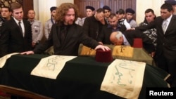 Omar Chatah, son of former Lebanese minister Mohamad Chatah, who was killed in a bomb blast on Friday, stands next to his father's coffin during his funeral at al-Amin mosque in Martyrs' Square in downtown Beirut, Dec. 29, 2013.