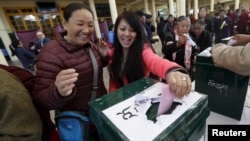 Tibetan exiles react as they cast their vote during the elections for the Tibetan government-in-exile at a polling booth in Dharamsala, India, March 20, 2016. 