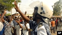 Opposition activists chant slogans towards a police officer during demonstrations in Lome, 09 March 2010