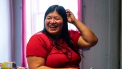 Keldy Mabel Gonzales Brebe smiles as she makes a meal for her family in the Kensington section of Philadelphia, Sunday, May 16, 2021.