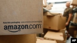 FILE - An Amazon package awaits delivery in Palo Alto, California. The online retailer is suing more than 1,000 people for advertising their services writing fake reviews.