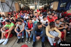 FILE - Migrants wait to disembark from the Vos Hestia ship as they arrives in the Crotone, Italy, after being rescued by a Save the Children crew in the Mediterranean sea off the Libya coast, June 21, 2017.