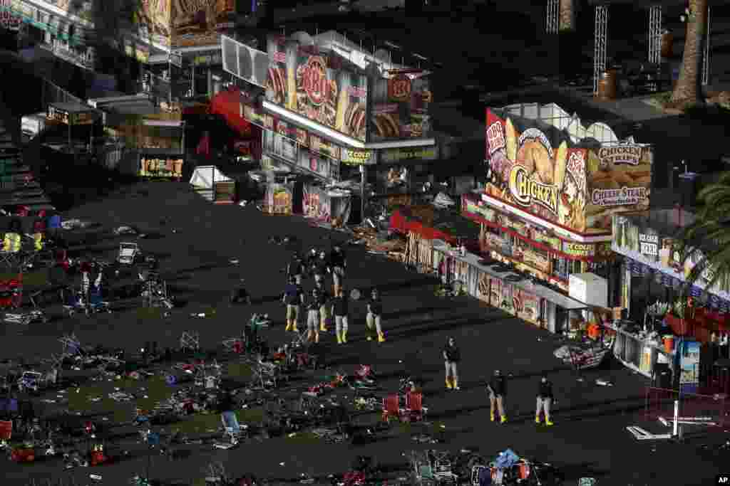 Investigators work at a festival ground across the street from the Mandalay Bay Resort and Casino, in Las Vegas, Nevada, Oct. 3, 2014. Authorities said Stephen Craig Paddock broke windows on the casino and began firing with a cache of weapons, killing dozens and injuring hundreds at the music festival on Sunday.