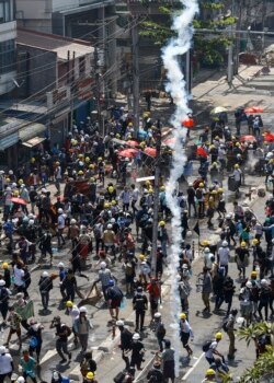 Para pengunjuk rasa lari ketika pihak berwenang menembakkan gas air mata untuk membubarkan aksi demo menentang kudeta militer di Yangon, 1 Maret 2021. (Foto oleh STR / AFP)