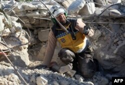 A member of the opposition's Syrian Civil Defense reacts as he prepares to recover the body of a woman buried under the rubble of a building, following shelling by government forces in the village of Rakaya Sijneh, Idlib province, Syria, May 4, 2019.