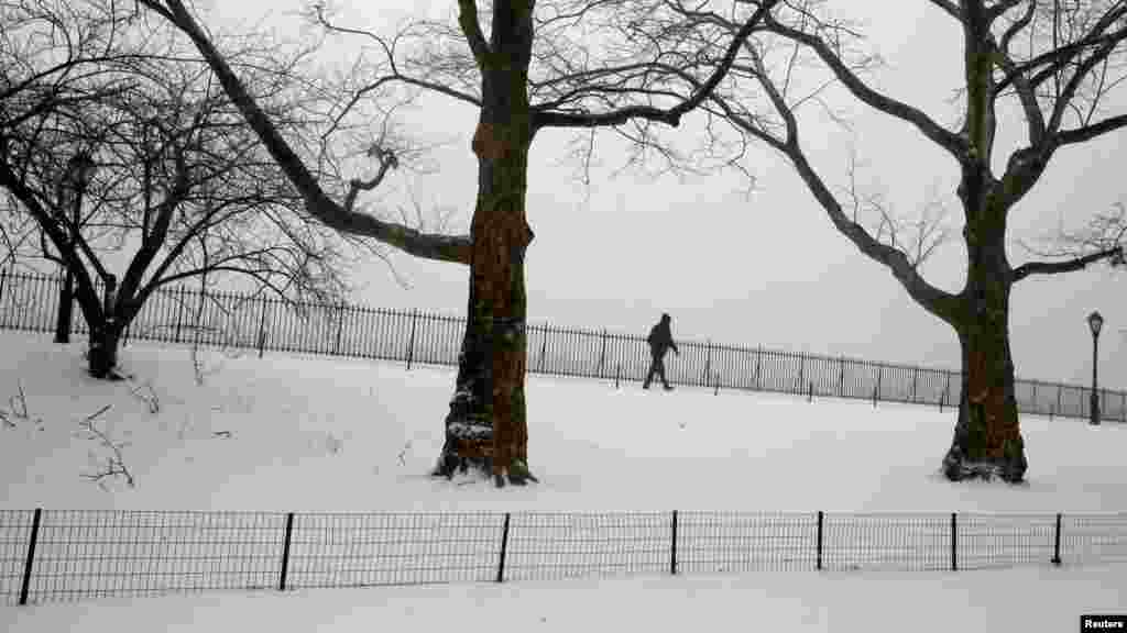 Un homme marche dans la neige tombe au Central Park à Manhattan, New York, le 14 mars 2017.