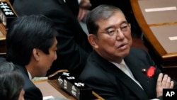 Japanese Prime Minister Shigeru Ishiba, right, speaks with other lawmakers prior to a Diet session at the Upper House of the Parliament, Oct. 4, 2024, in Tokyo. 