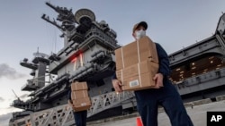 Sailors assigned to the aircraft carrier USS Theodore Roosevelt move ready to eat meals for sailors who have tested negative for COVID-19 and are being taken to local hotels in an effort to implement social distancing at Naval Base Guam,April 7, 2020.