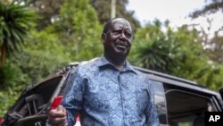 FILE - Kenya's opposition leader Raila Odinga speaks next to one of his vehicles he says was struck by a teargas canister fired by riot police, at his home in Nairobi, Kenya, March 31, 2023. 