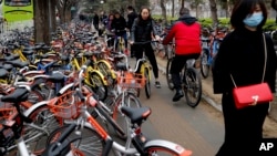 Residents ride bicycles from bike-sharing companies in Beijing, China. March 23, 2017. (AP Photo/Andy Wong)