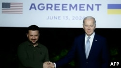 Президент України Володимир Зеленський і президент США Джо Байден підписують двосторонню угоду про безпеку під час прес-конференції на полях саміту G7