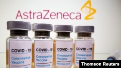 FILE PHOTO: Vials and medical syringe are seen in front of AstraZeneca logo in this illustration