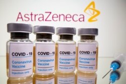 Ampul vaksin Covid-19 dan suntikan di depan tulisan AstraZeneca.
