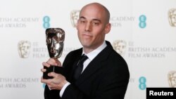 Joshua Oppenheimer dengan piala film dokumenter terbaik untuk filmnya "The Act Of Killing" pada acara British Academy of Film and Arts (BAFTA) di Royal Opera House, London (16/2). (Reuters/Suzanne Plunkett)