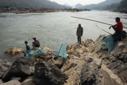 FILE - Fishermen cast their nets on the Mekong River near Luang Prabang, Laos, close to the site of a future dam, Feb. 8, 2020.