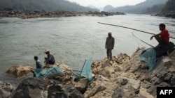 这张拍摄于2020年2月8日的照片显示，渔民正在琅勃拉邦附近的湄公河上铺设渔网，该河段靠近老挝一个已获批准的大坝所在地。（资料照片）