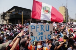 FILE - People react after Peru's interim President Manuel Merino announced his resignation, in Lima, Peru, Nov. 15, 2020.