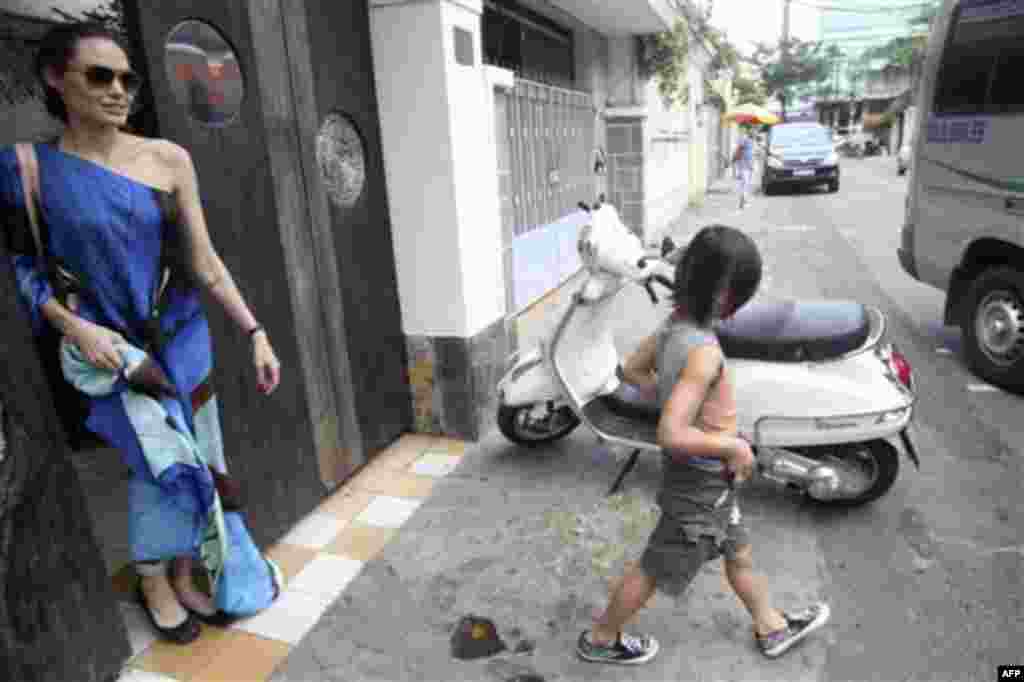 American actress Angelina Jolie, left, and her adopted son Pax Thien leave a Vietnamese restaurant in Ho Chi Minh City, Vietnam, after lunch on Friday, Nov. 11, 2011. Hollywood power couple Jolie and Brad Pitt and their six children are on a visit to Viet