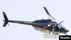 FILE - A law enforcement helicopter is seen near the scene where police officers were shot in Baton Rouge, Louisiana.