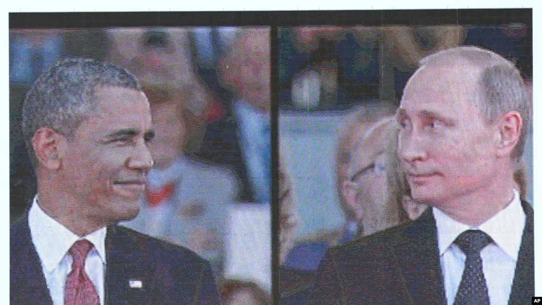 Na velikim ekranima vide se predsednik Barak Obama i ruski predsednik Vladimir Putin dok stižu na svečanost obeležavanja 70. godišnjice Dana D u Uistreamu u Normandiji, 6. juna 2014.