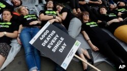 FILE - Supporters stage a 'Die-In' to mark World Hepatitis Day at Piccadilly Circus in London.