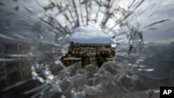 FILE - The city of Mekele is seen through a bullet hole in a stairway window of the Ayder Referral Hospital in the Tigray region of northern Ethiopia on May 6, 2021. 