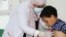 FILE - Nahla Arishi, a pediatrician, checks a boy infected with diphtheria at the al-Sadaqa teaching hospital in the southern port city of Aden, Yemen, Dec. 18, 2017. 